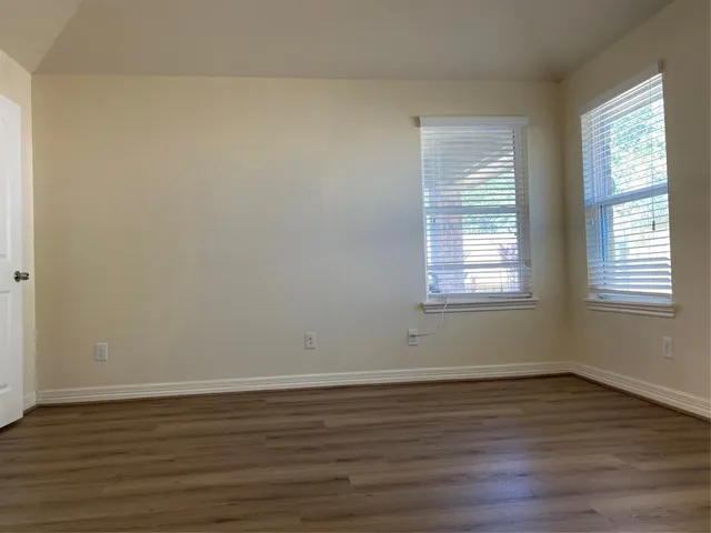 a view of a room with wooden floor and window