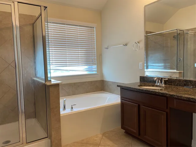 a bathroom with a tub sink and mirror