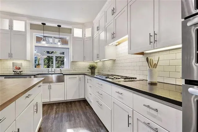 a kitchen with granite countertop white cabinets and white appliances