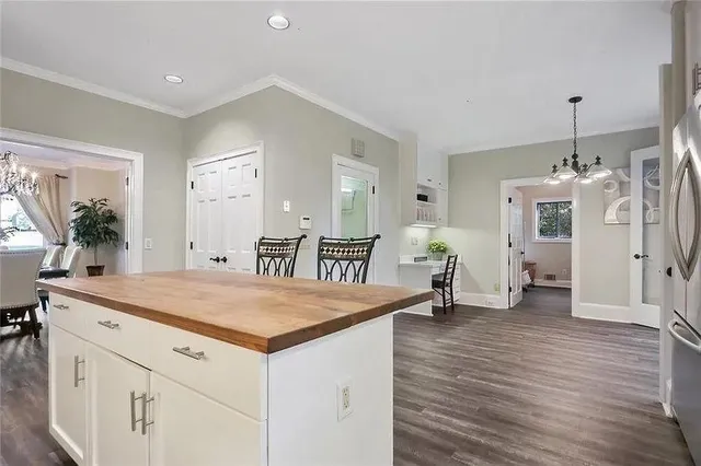 a room with a chandelier and wooden floor