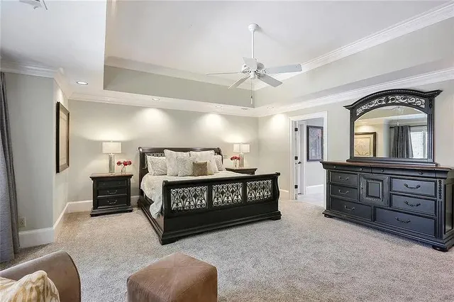 a spacious bedroom with a bed dresser and a window