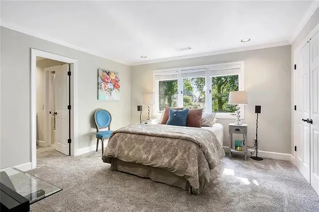 a bedroom with a bed and a large window