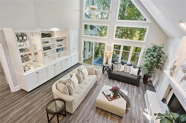 a living room with furniture and a large window with wooden floor