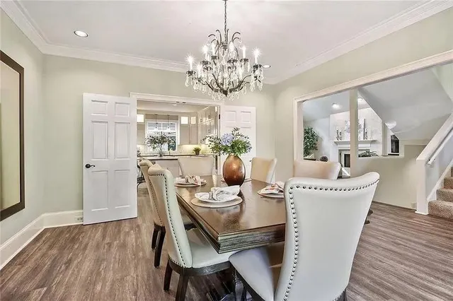a dining room with furniture a chandelier and wooden floor