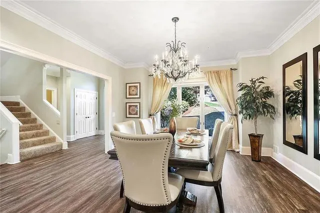 a dining room with furniture a chandelier and wooden floor