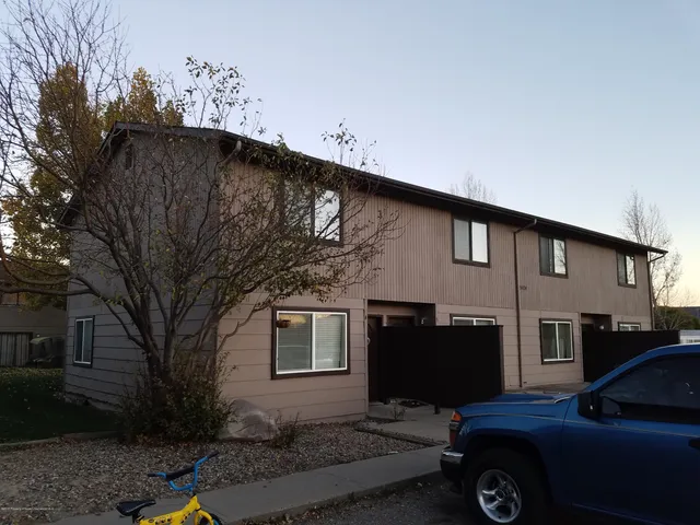 a car parked in front of a white house