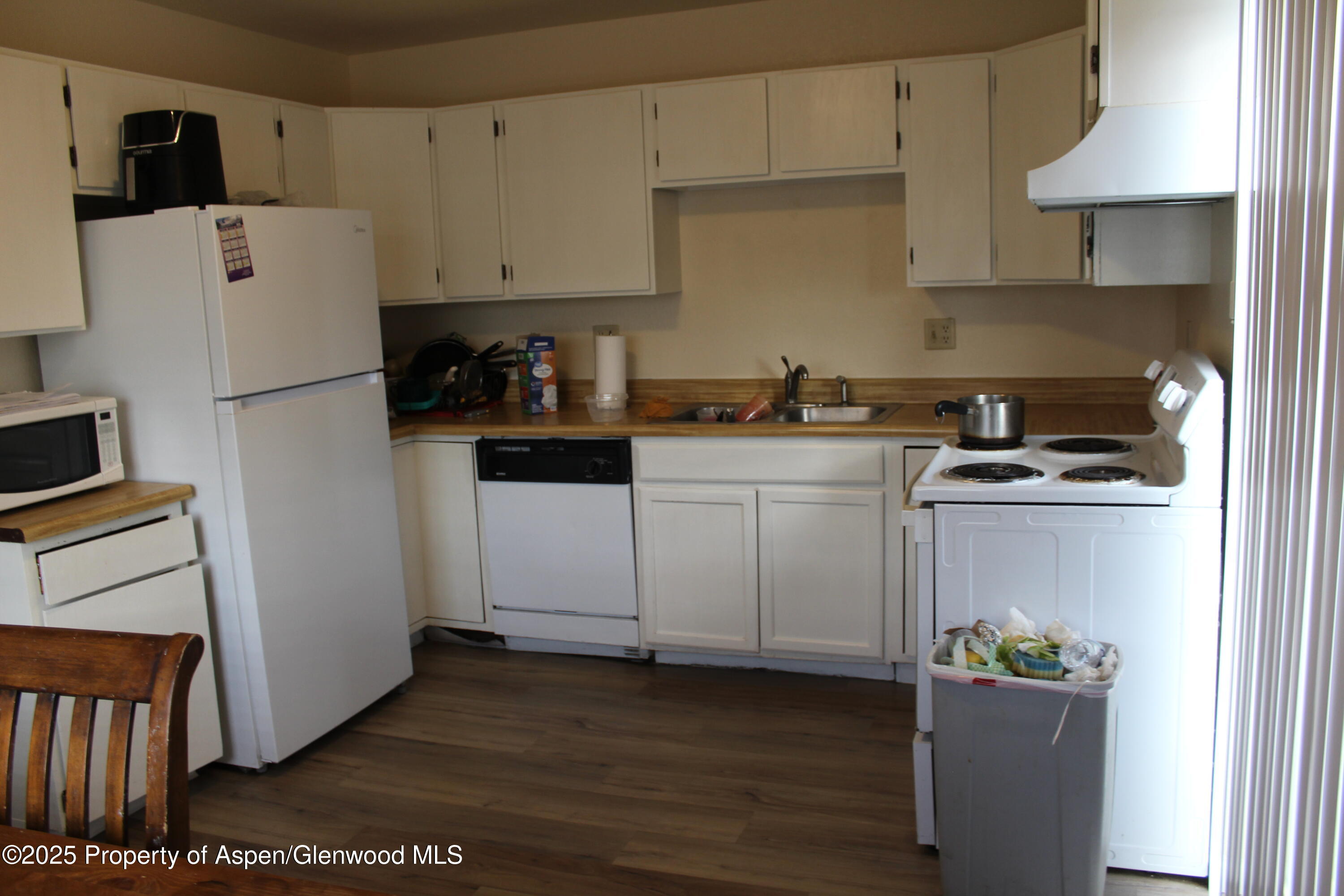 2404 West Avenue Rifle, CO 81650 - Photo 5 of 8 a kitchen with a refrigerator and a stove top oven