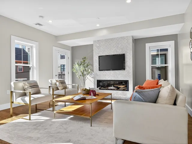 a living room with furniture a fireplace and a flat screen tv