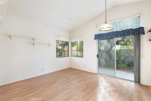 a view of a white house with a small yard and large tree