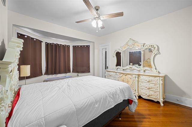 2746 John F. Kennedy Boulevard Jersey City, NJ 07306 - Photo 17 of 37 a spacious bedroom with a bed a dresser and wooden floor