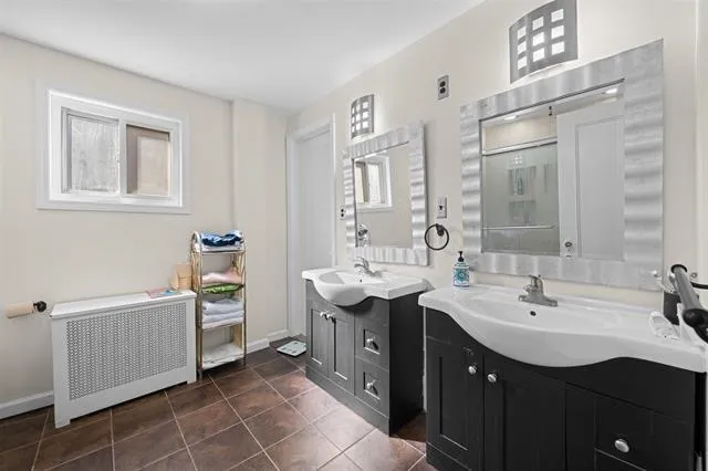 a bathroom with a double vanity sink a mirror and a bathtub