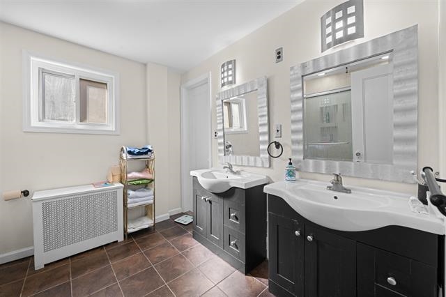 2746 John F. Kennedy Boulevard Jersey City, NJ 07306 - Photo 19 of 37 a bathroom with a double vanity sink a mirror and a bathtub