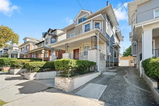 a front view of a multi story residential apartment building with yard and green space
