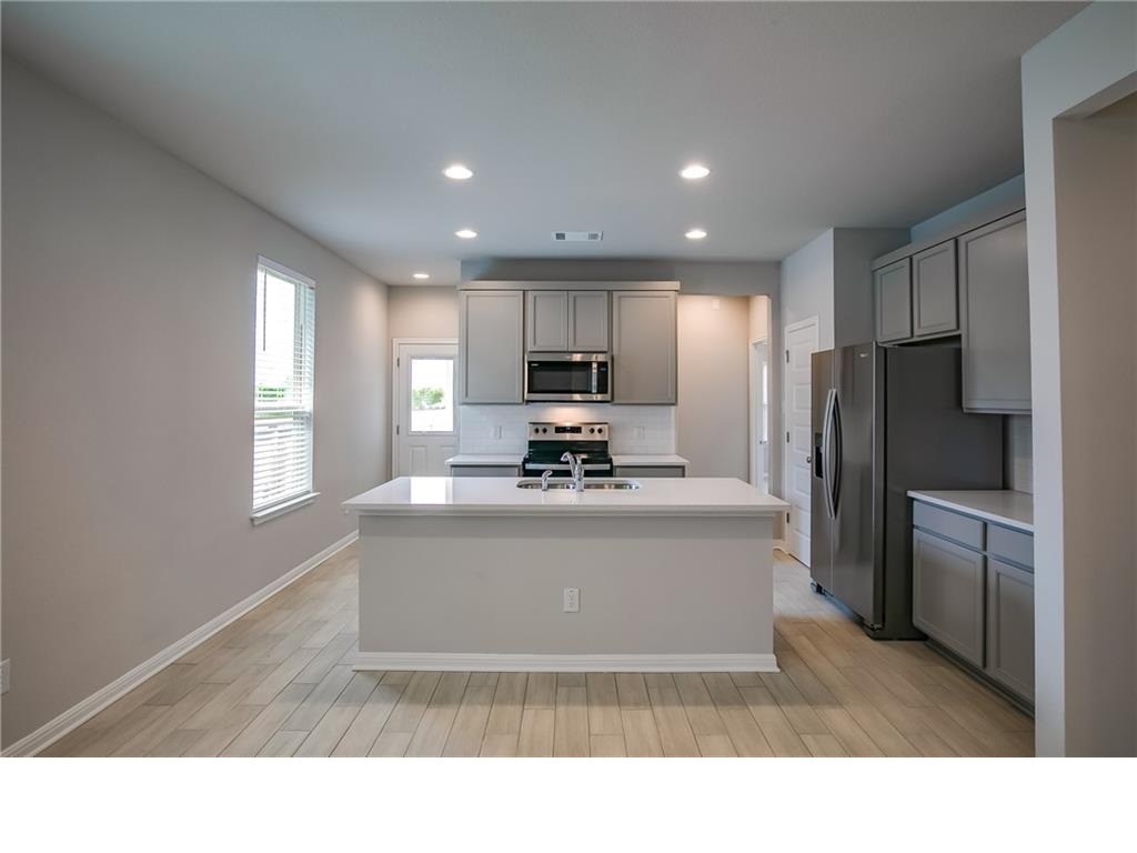 237 Unforgiven Lane Jarrell, TX 76537 - Photo 6 of 20 a view of kitchen with refrigerator stove a sink and dishwasher