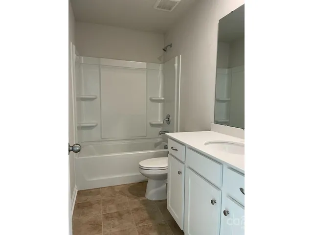a bathroom with a granite countertop toilet a sink and bathtub