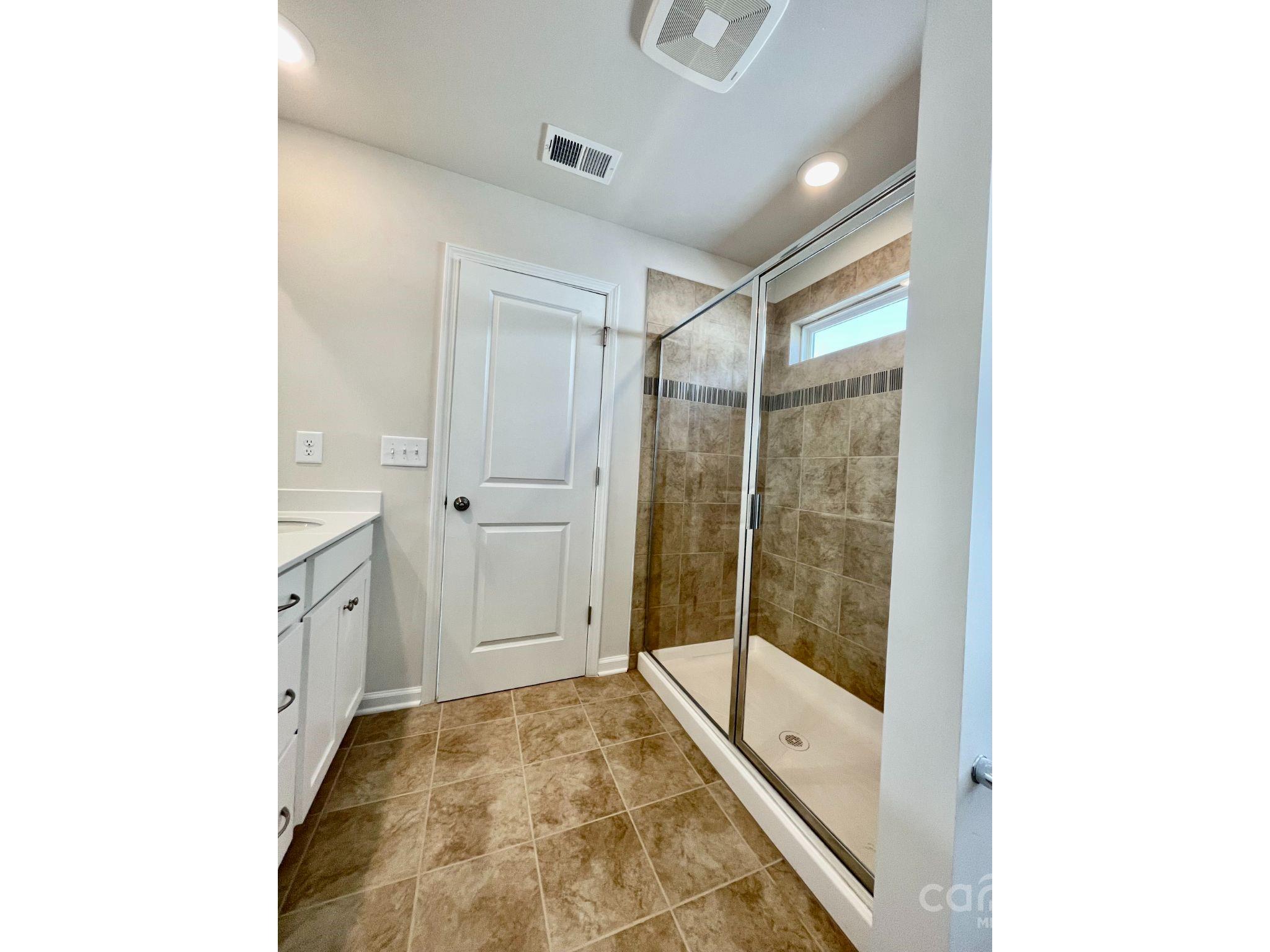 15904 Capps Road Charlotte, NC 28278 - Photo 9 of 21 a bathroom with a glass shower door and a bathtub