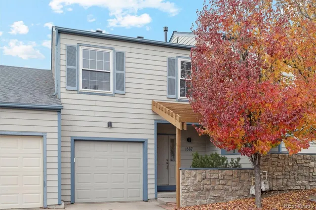 a front view of a house with plants