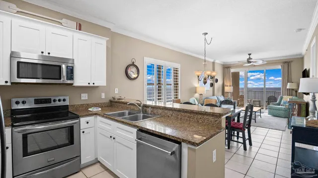 a kitchen with granite countertop stainless steel appliances a stove sink and microwave