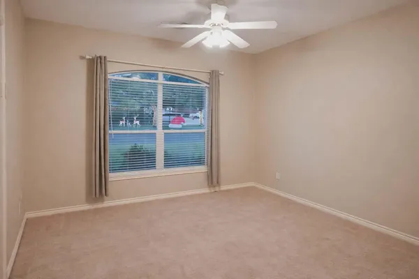 an empty room with windows and fan