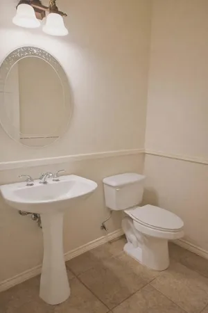 a bathroom with a toilet sink and mirror