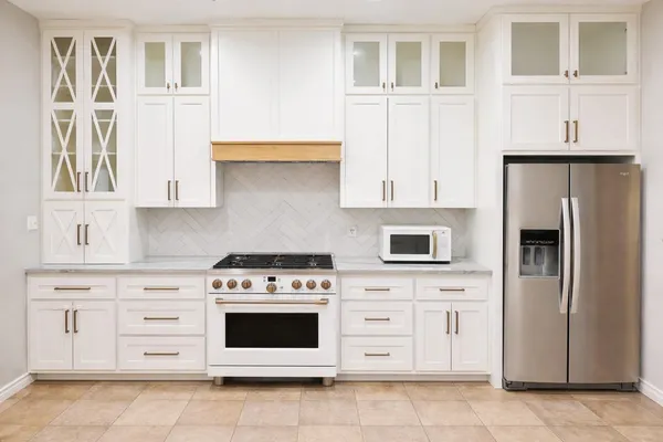 a kitchen with granite countertop white cabinets and stainless steel appliances