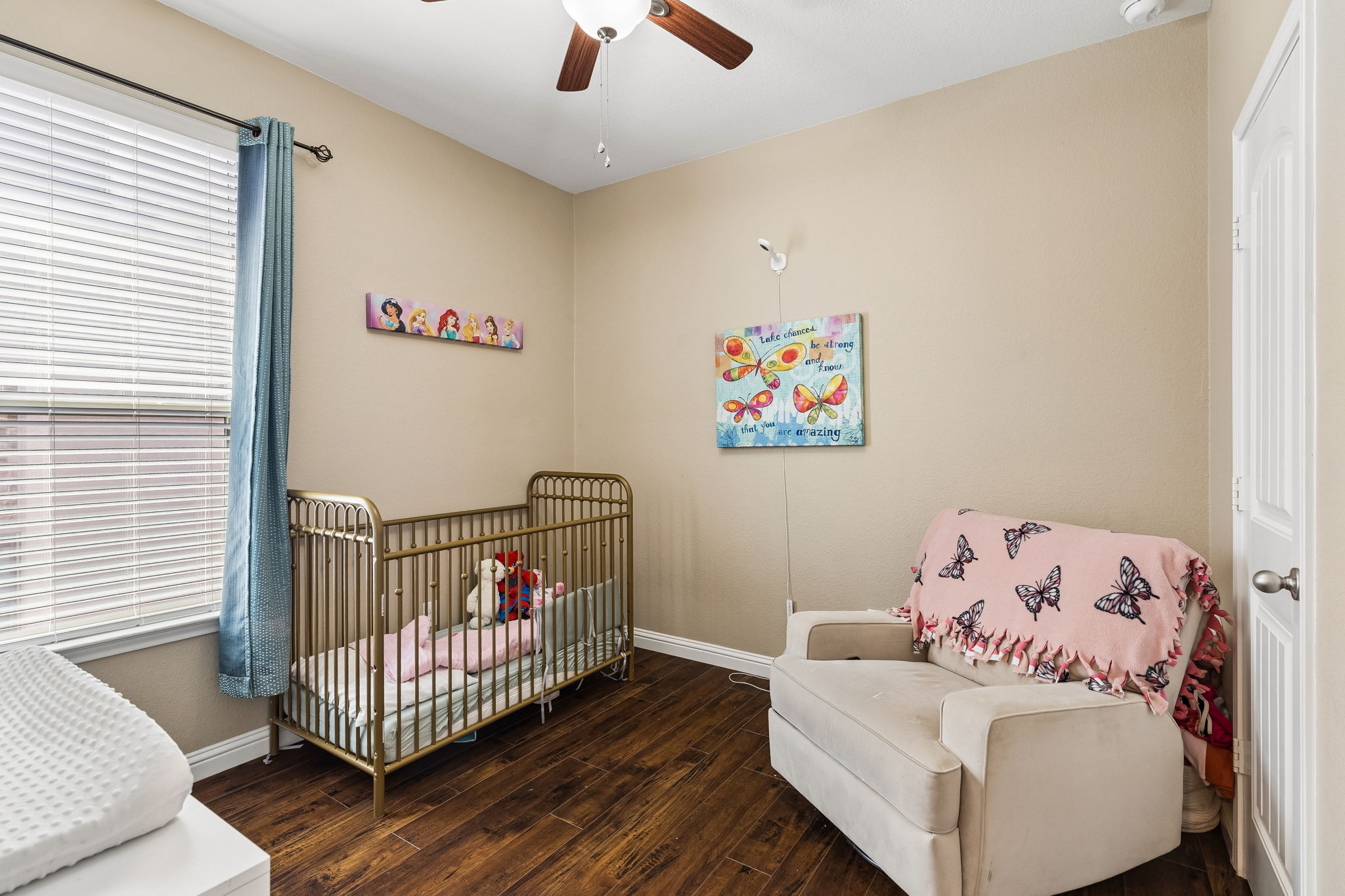 1113 Yellow Iris Road Leander, TX 78641 - Photo 17 of 26 Rich wood floors and a large window create a warm, inviting atmosphere in this bedroom.