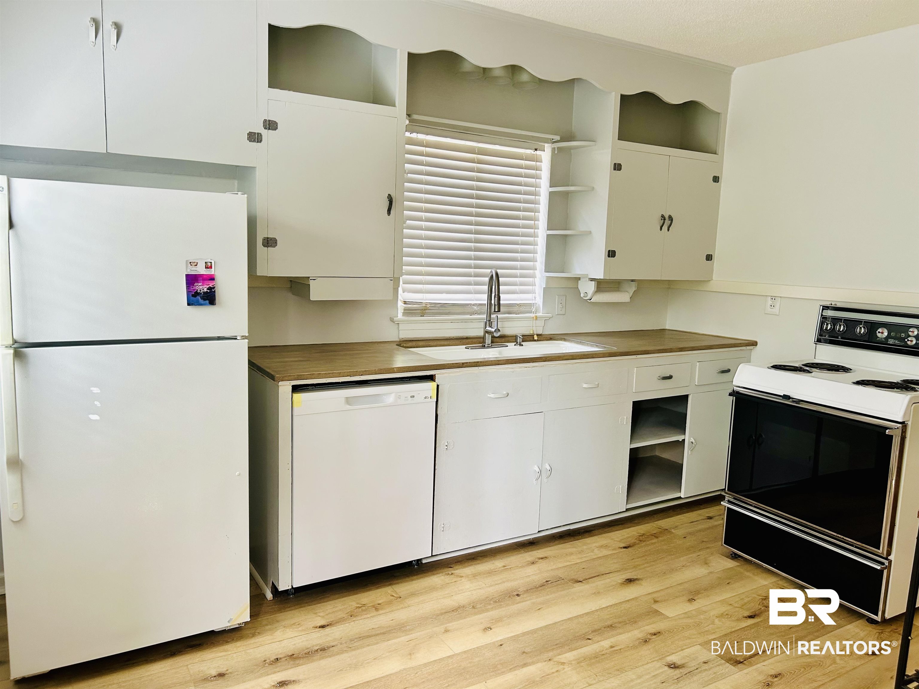 94 Diamond Street Mobile, AL 36611 - Photo 15 of 30 Kitchen with wood counters, sink, white cabinetry, light hardwood / wood-style flooring, and white appliances