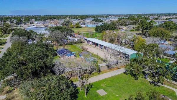 an aerial view of residential houses with outdoor space and swimming pool