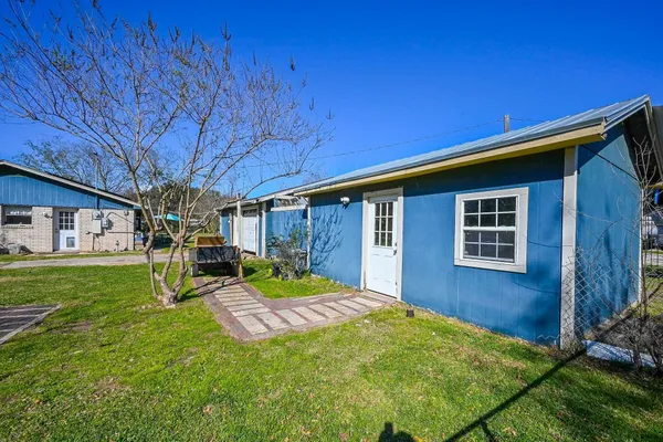 a front view of a house with a yard and trees