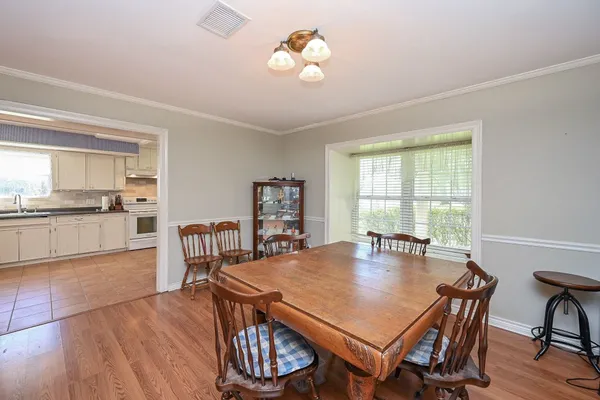 a living room with stainless steel appliances furniture a rug and a window