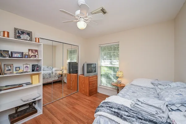 a bedroom with a bed and a flat screen tv on dresser