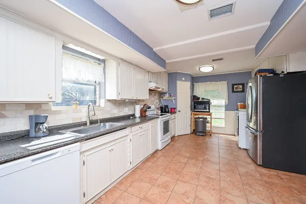a kitchen with stainless steel appliances granite countertop a stove and white cabinets