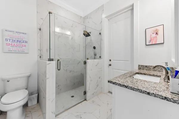 a bathroom with a granite countertop sink toilet and shower