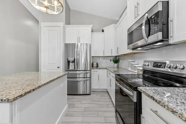 a kitchen with stainless steel appliances granite countertop a stove a refrigerator and a sink