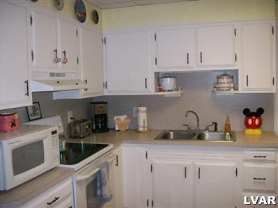 835 Spring Street Bethlehem, PA 18018 - Photo 8 of 12 a kitchen with white cabinets and white appliances