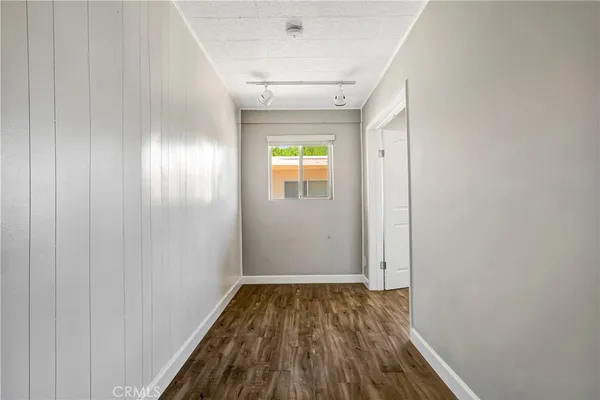a view of empty room with wooden floor