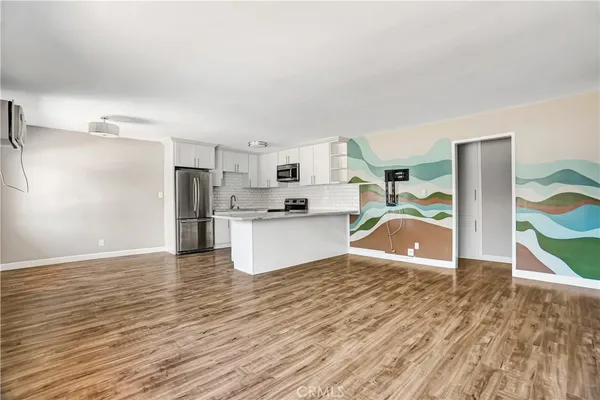 a view of kitchen with refrigerator microwave and wooden floor