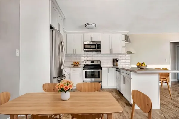 a kitchen with stainless steel appliances granite countertop a stove refrigerator and microwave