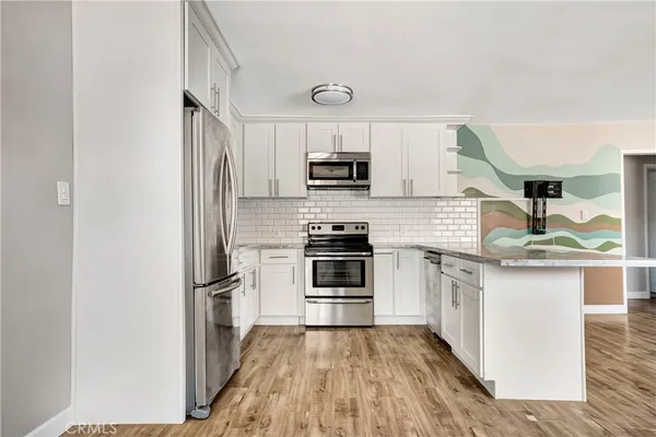 a kitchen with stainless steel appliances granite countertop a stove a sink and a refrigerator