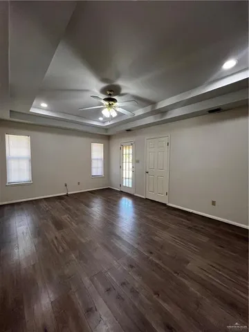 an empty room with wooden floor and chandelier