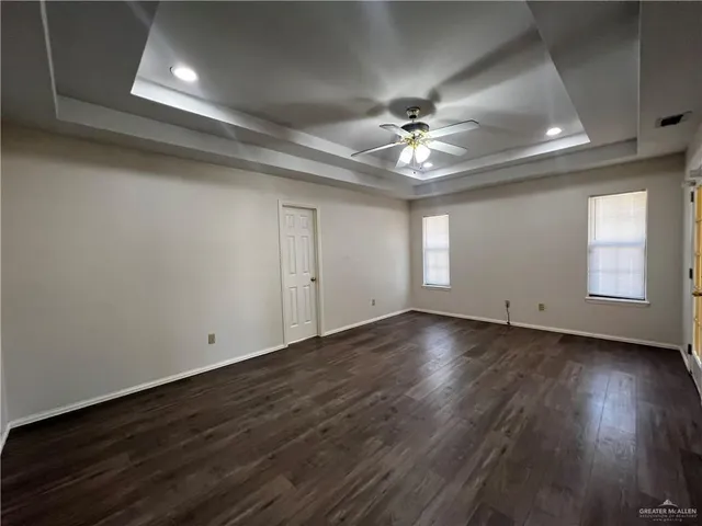 an empty room with wooden floor and chandelier fan