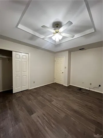 a view of an empty room with wooden floor