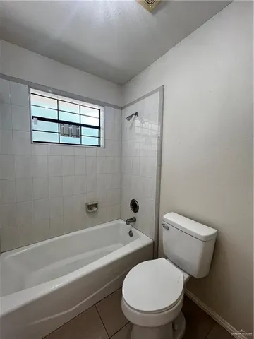 a white toilet sitting next to a bath tub