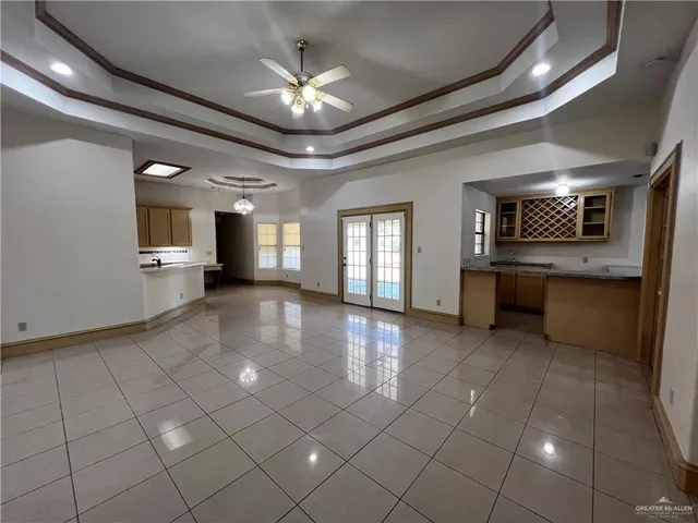 an empty room with a fireplace and chandelier