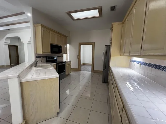 a kitchen with a sink and a stove top oven