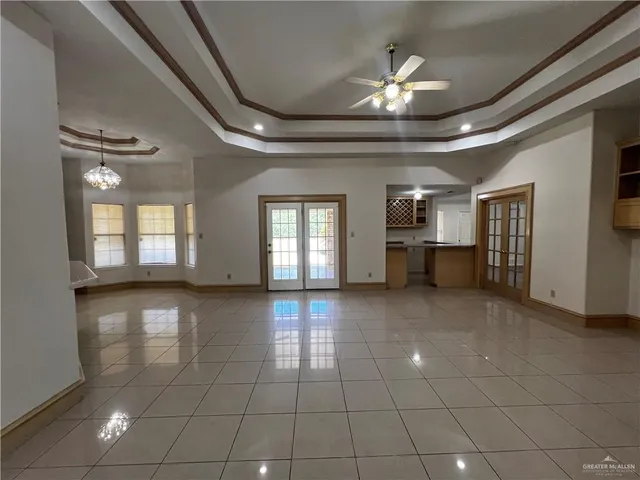 a view of a livingroom with a chandelier fan and windows