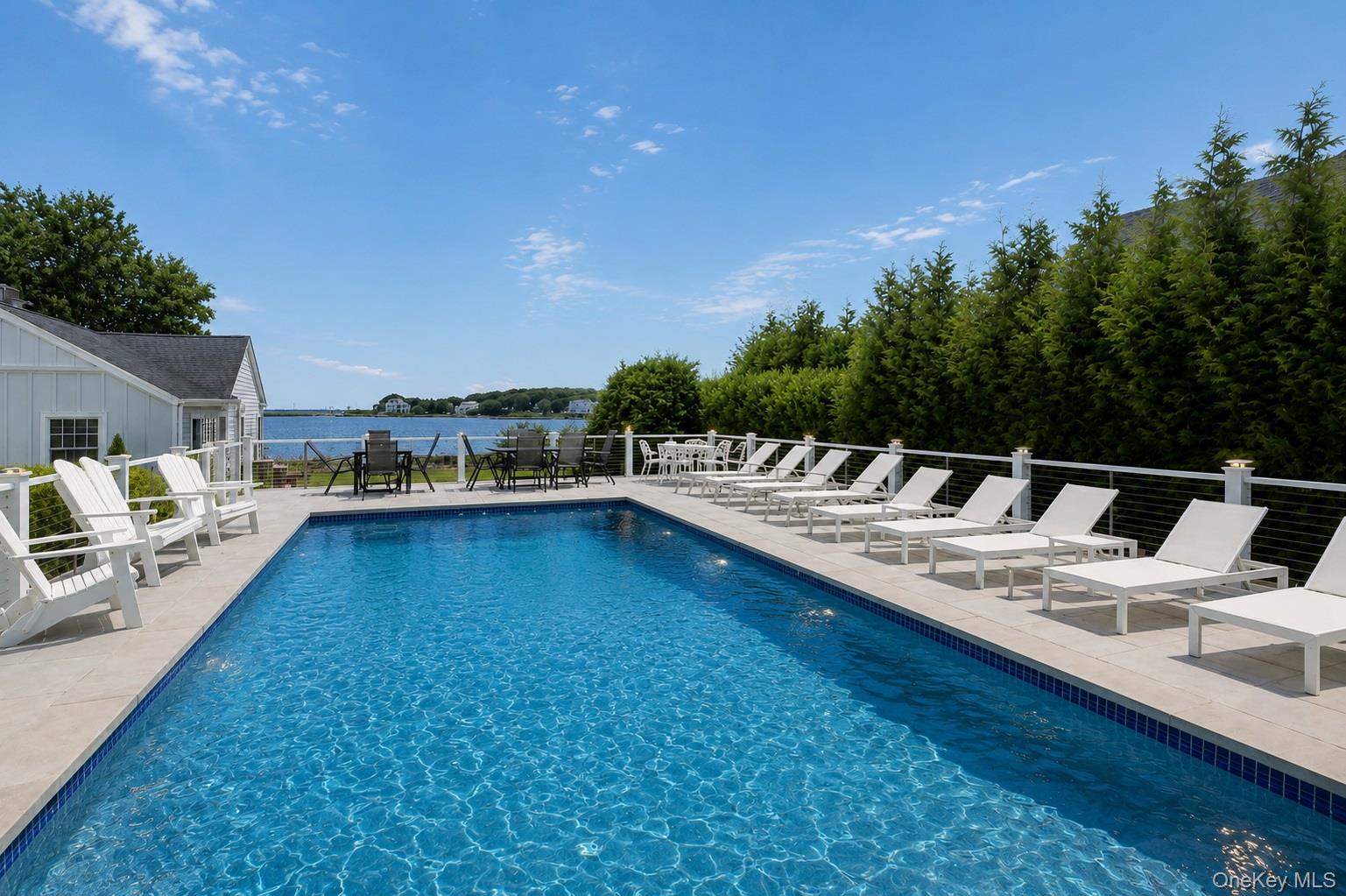65 Shore Road Westhampton, NY 11977 - Photo 23 of 24 Outdoor swimming pool featuring a light-colored tile surround and a water view