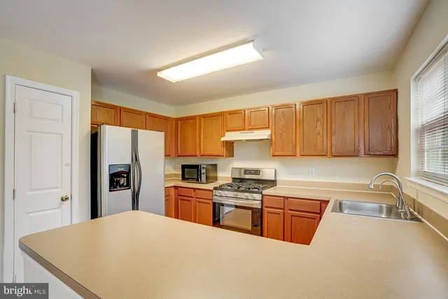 a kitchen with stainless steel appliances a refrigerator stove microwave and sink