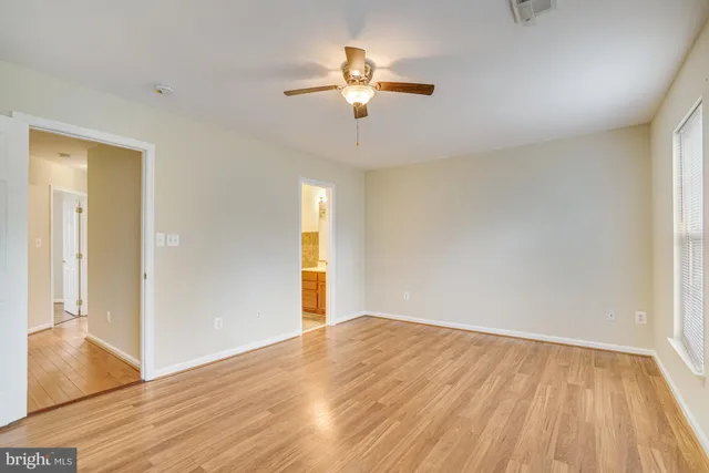 a view of a livingroom with wooden floor and a ceiling fan