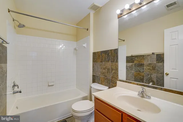 a bathroom with a sink mirror toilet and bathtub